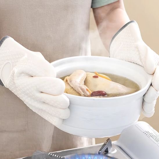 Une personne qui dépose un plat de soupe sur une gazinière