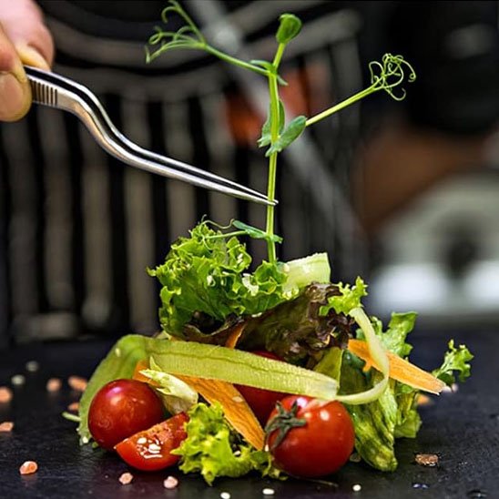 pince qui tient une feuille de salade pour la déco