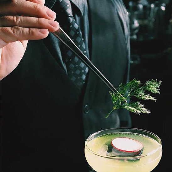 pince qui tient de la menthe dans un coktails