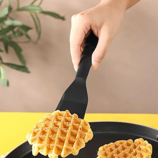 1 spatule noir  qui retourne une gauffre