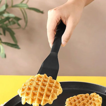 1 spatule noir  qui retourne une gauffre