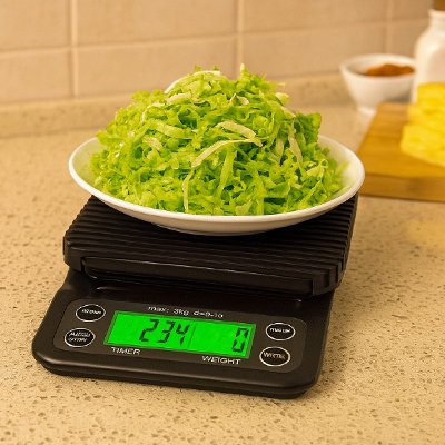 Balance cuisine noir avec assiette de légumes verts