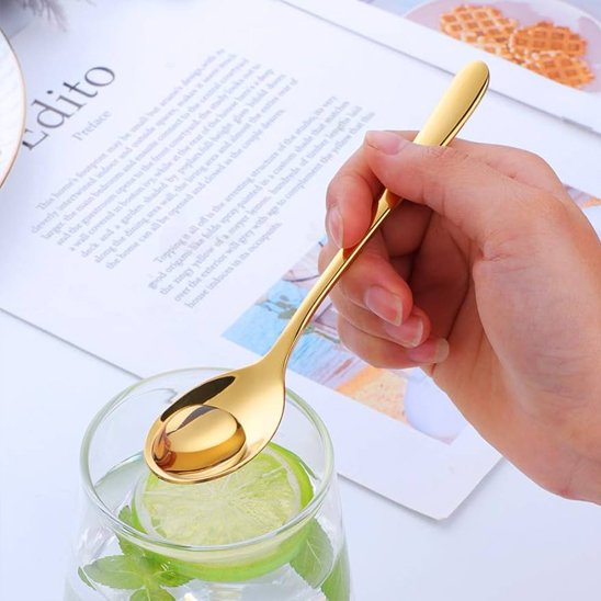 Cuillère à café gold brillant dans une main