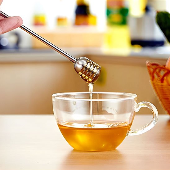 Cuillère à miel sur une table avec une tasse