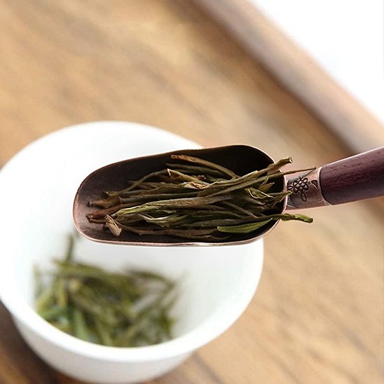 Cuillère à thé versant les feuilles dans une tasse