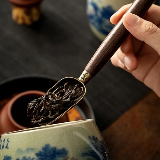 Cuillère à thé prenant les feuilles de thés