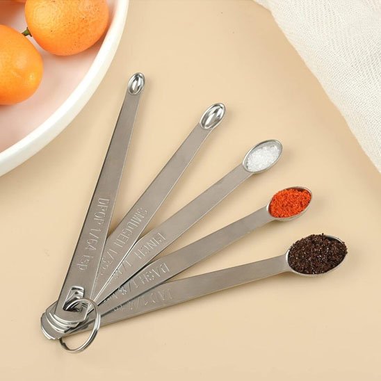 Cuillère doseuse sur une table à coté d'un plat 