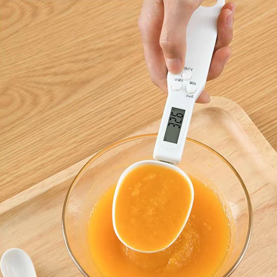 Cuillère doseuse​ avec de la purée de fuits