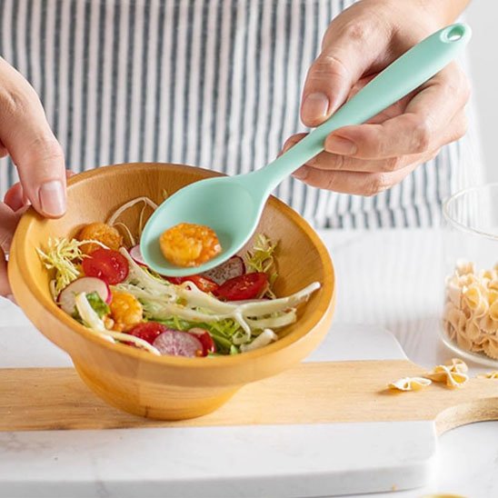 Cuillère remuant une salade dans un bol
