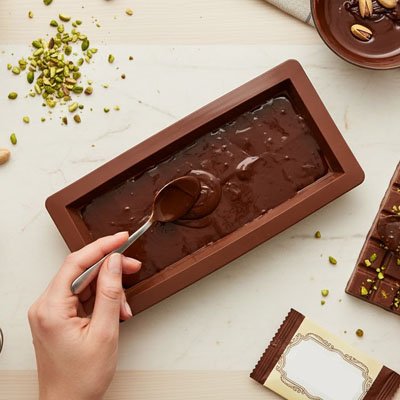 Moule remplit de chocolat avec une cuillère