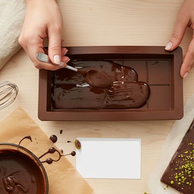 personne qui remplit le moule avec une cuillère