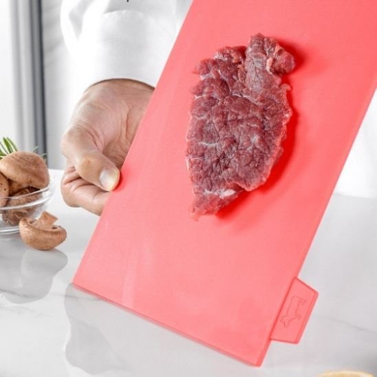 Planche à découper dans une main avec de la viande