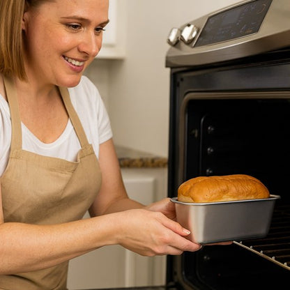 Une femme sortant un moule a pain du four