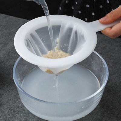 filtrage de l'eau dans une passoire blanche