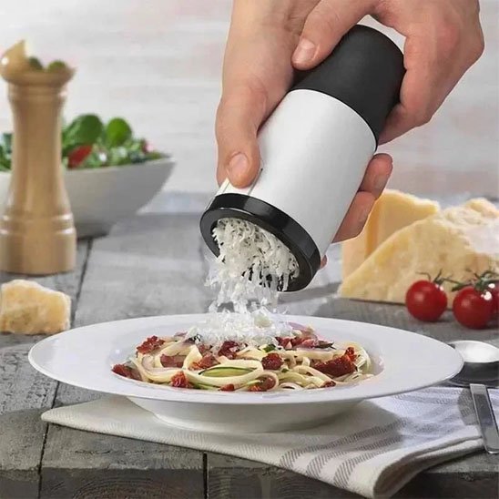 Râpe à fromage râpant du fromage sur une assiette