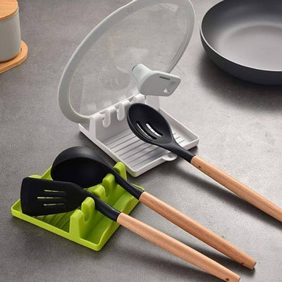 Repose cuillère vert anis et blanc avec des outils de cuisine