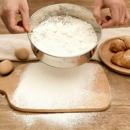 tamis de cuisine qui tamise sur une planche de pain de la farine